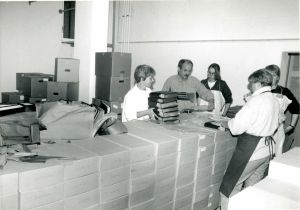 Mitarbeiterinnen und Mitarbeiter wickeln durchweichte Akten in Folie ein